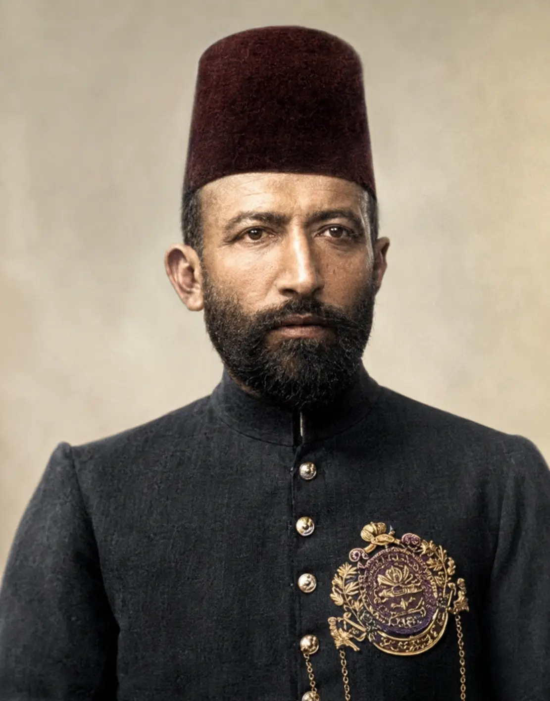 AI-generated impression: Colour portrait of Hakim Ajmal Khan, bearded, in a maroon fez and a dark high-collared buttoned coat bearing an ornate gold-and-purple medallion insignia, against a plain backdrop